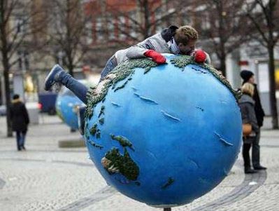 Người đàn ông nằm trên mô hình trái đất tại thành phố Copenhagen